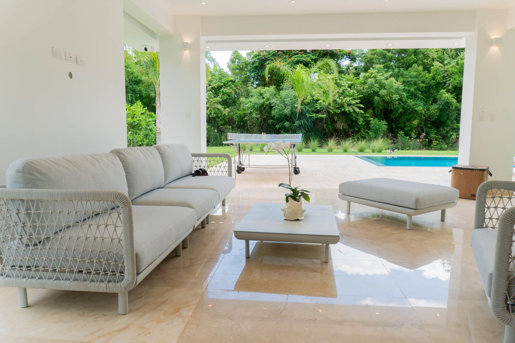 Terraza techada de la villa con sala exterior frente a la piscina